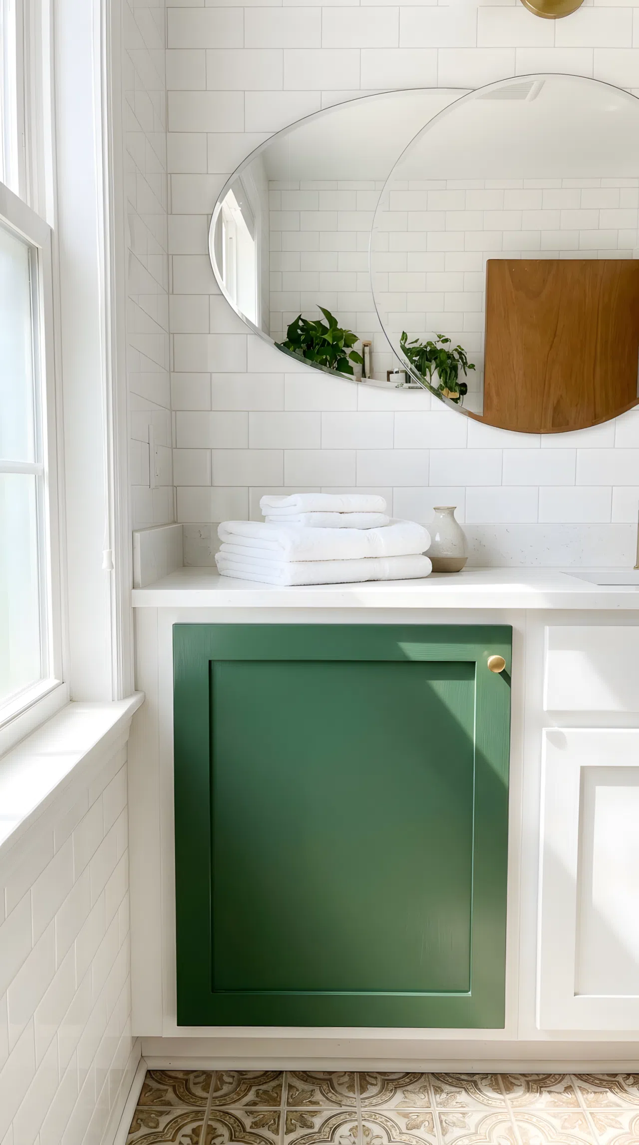 Real-life bathroom with a freshly painted forest green vanity cabinet door (RGB 53,94,59), white walls, simple round mirror, neatly organized countertop with folded towels, bright natural light highlighting the fresh paint finish, clean and beautifully arranged, photography style, vibrant color.